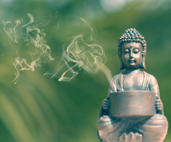Buddhist statue holding a bowl with burning incense