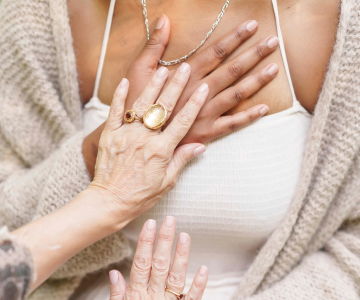 Women doing Reiki on another woman by placing hands on heart