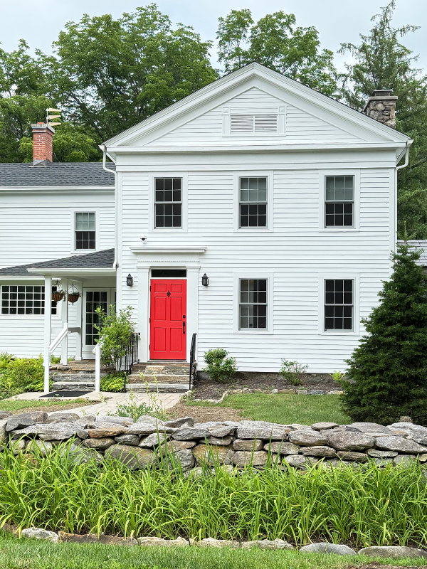 White Guest house with a red door at the Trinity Retreat Center.